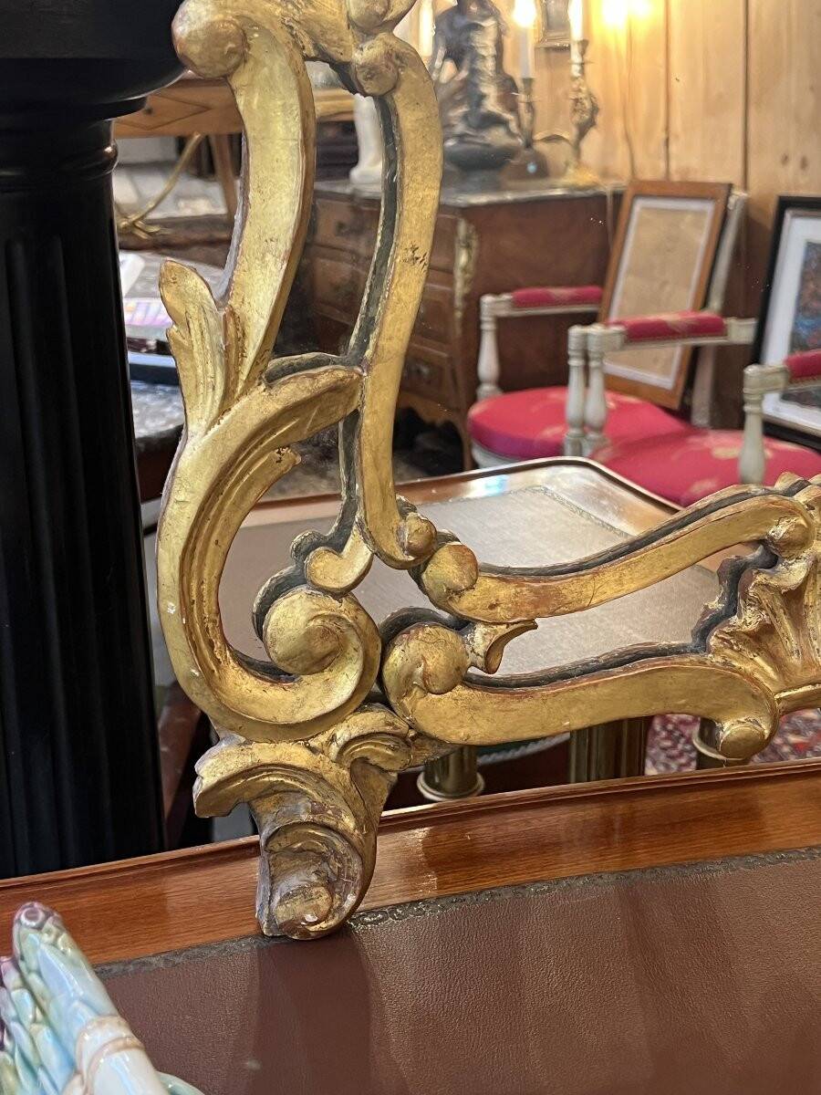 Mirror with carved and gilded wooden frame, 18th century, with scrollwork decoration.