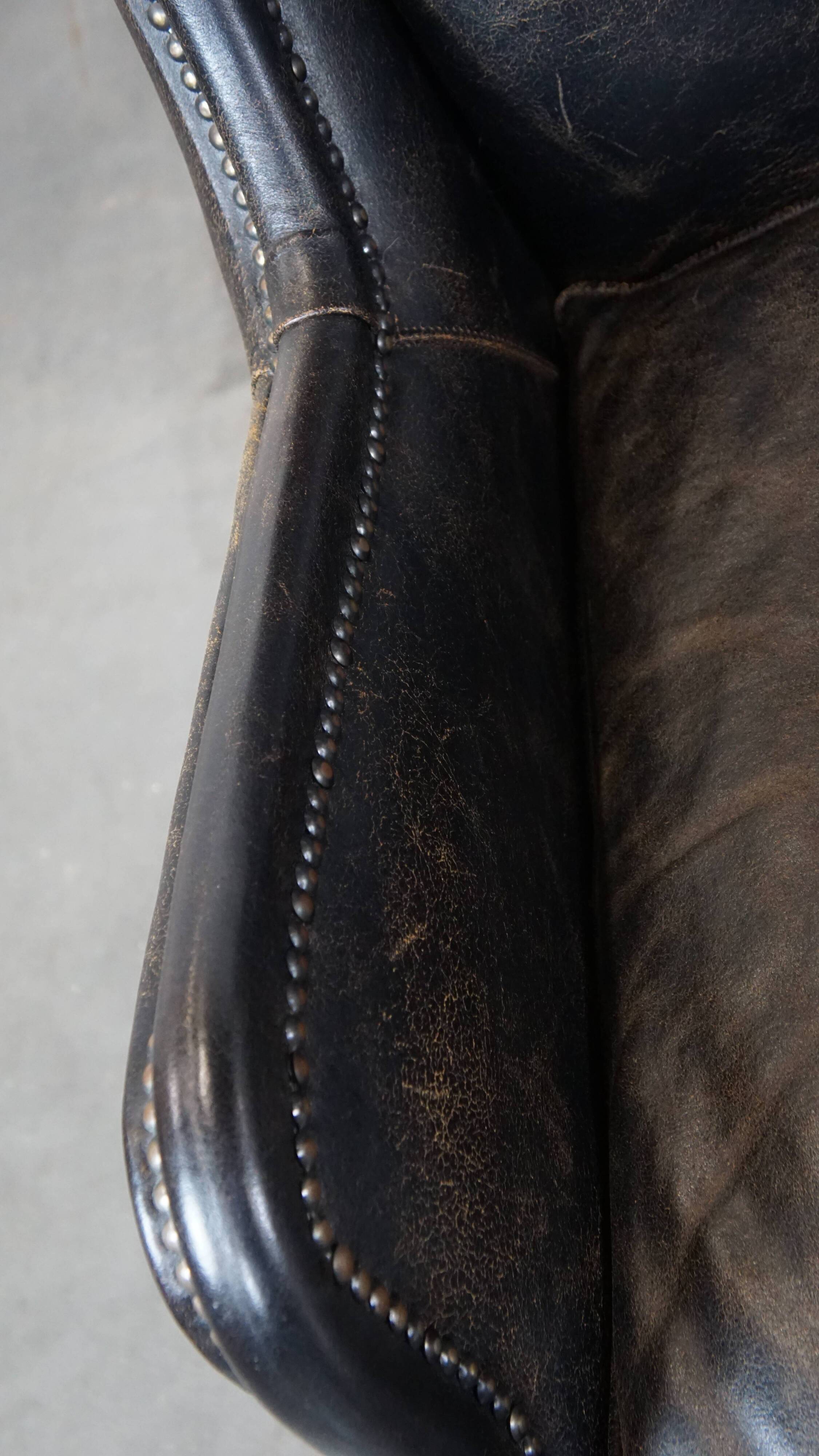 Set of 2 black cow leather armchairs finished with decorative nails, industrial style