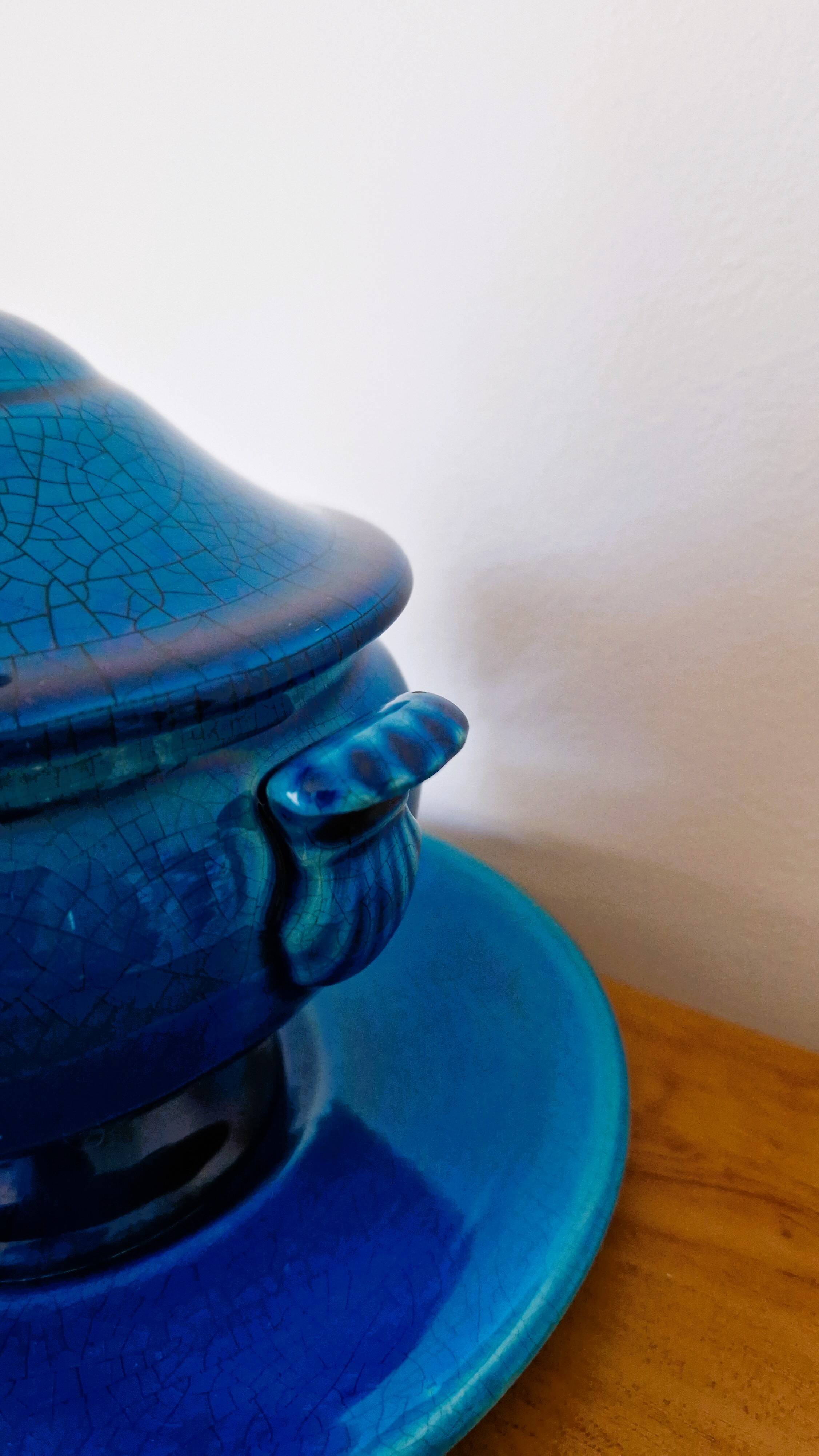 Blue ceramic soup tureen and crackled finish trivet.