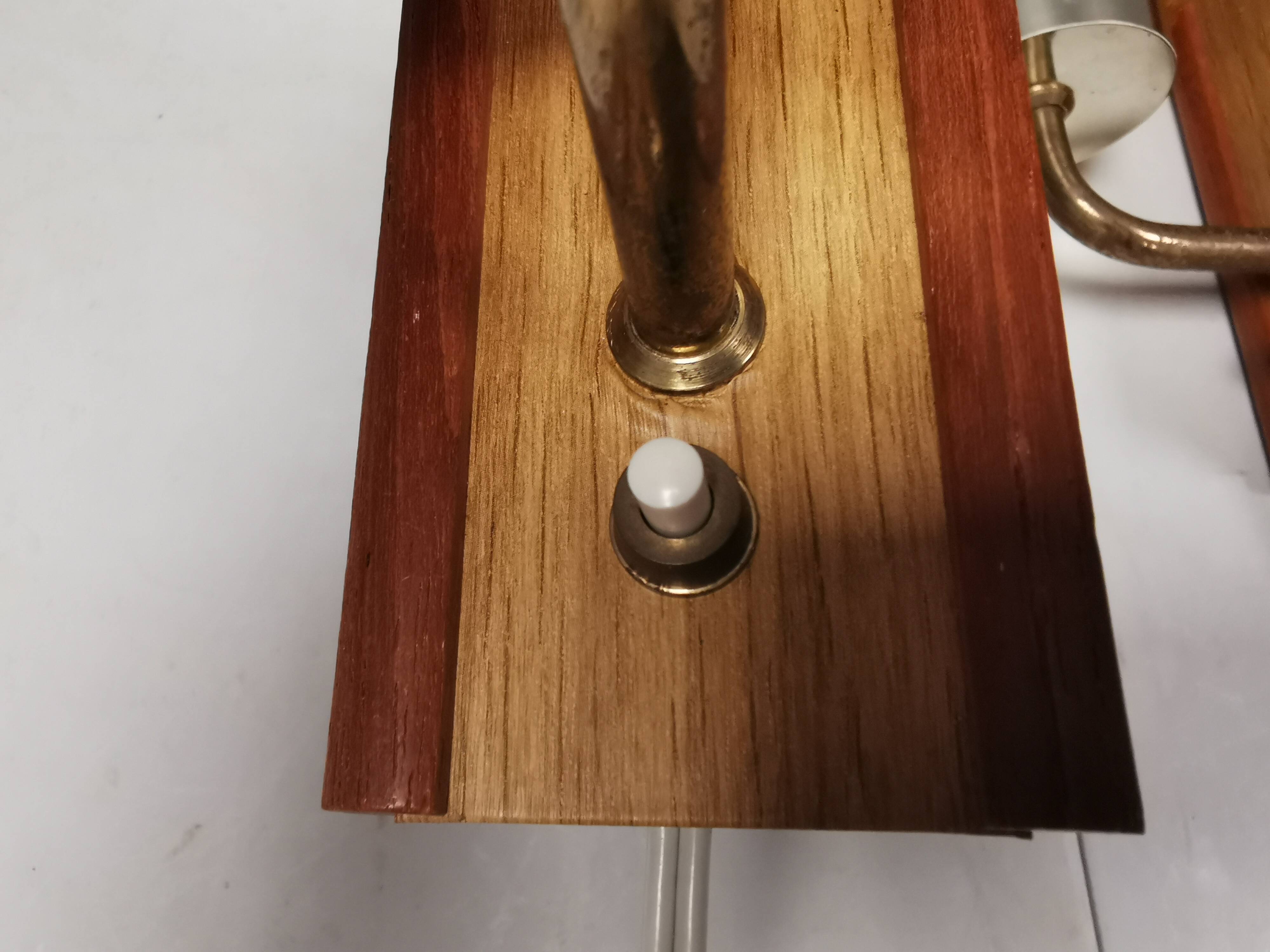 A set of wall lamps in teak wood, with amber colored glass