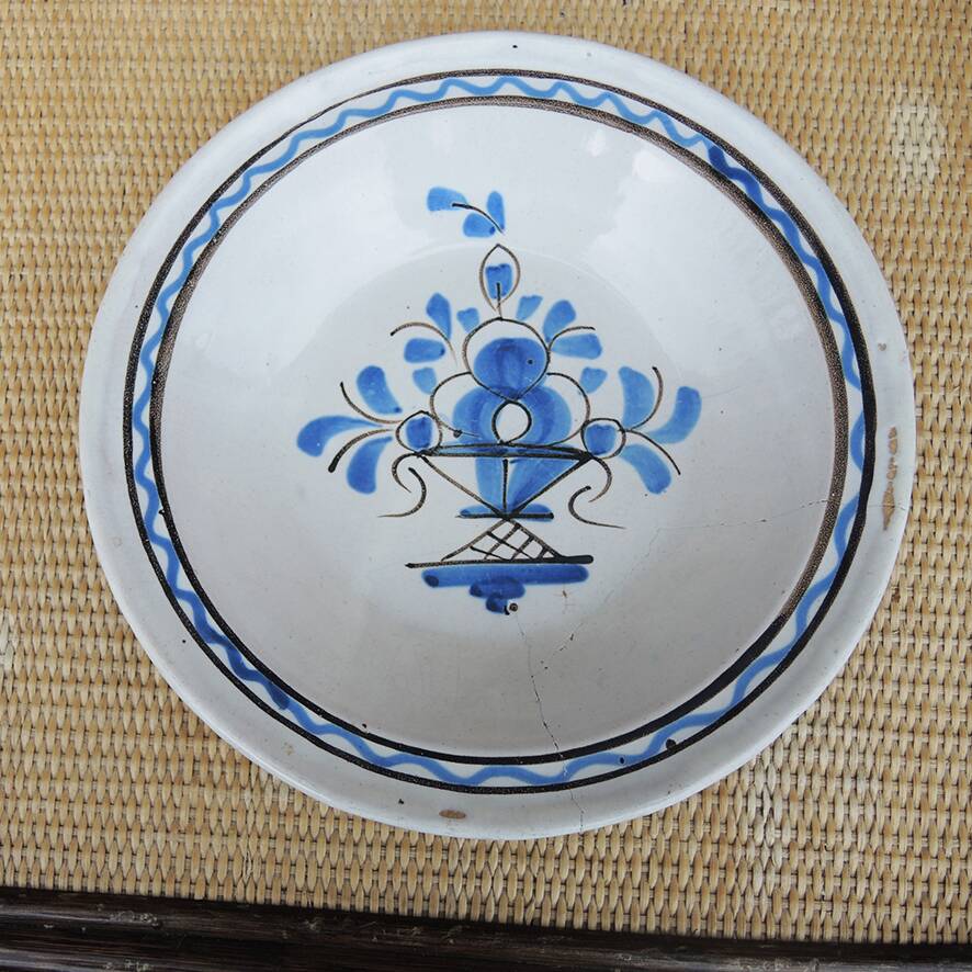 Old large round black ceramic dish