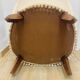 Pale pink upholstered armchair with wooden legs.