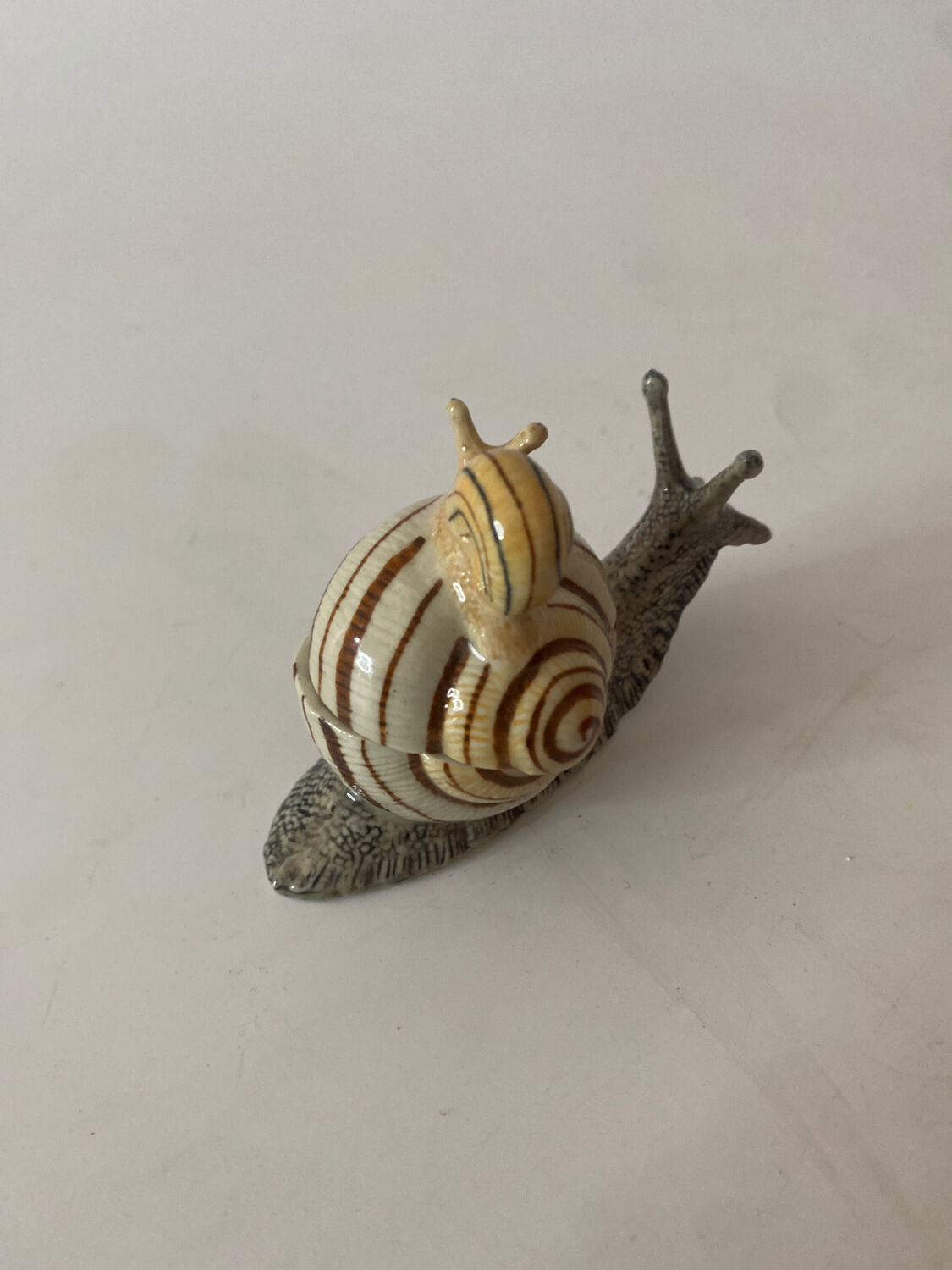 Porcelain figurine snail and its small