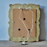 Old religious light frame in gilded stucco and curved glass