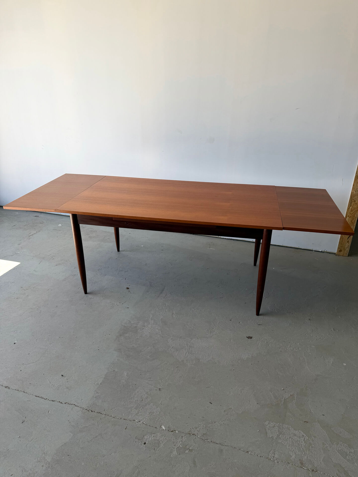 Rectangular extendable dining table with Scandinavian design in teak.