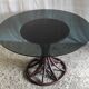 Round dining table tulip foot in rattan and smoked glass 70s