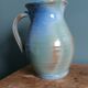Enamel pitcher in pastel blue and green, signed