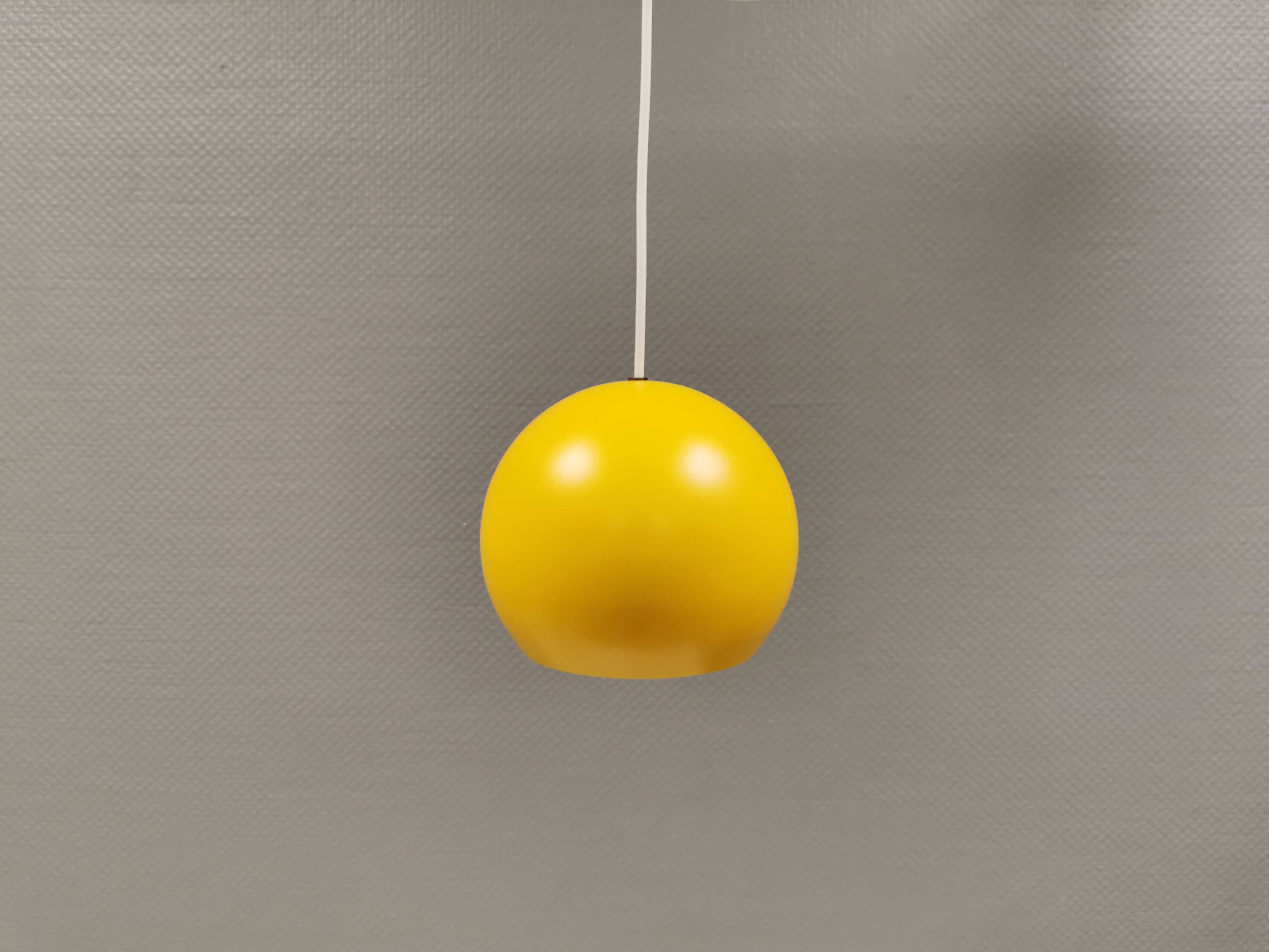 Spherical pendant lamp in sunny yellow.