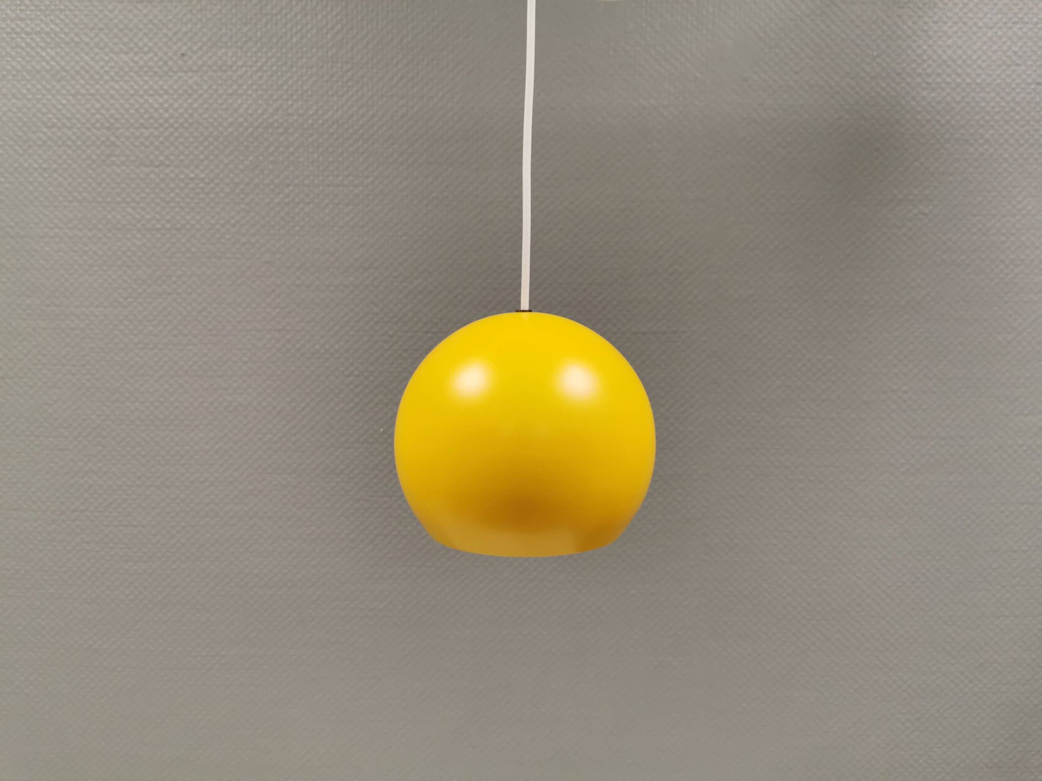 Lampe suspendue sphérique en jaune ensoleillé.