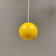 Lampe suspendue sphérique en jaune ensoleillé.