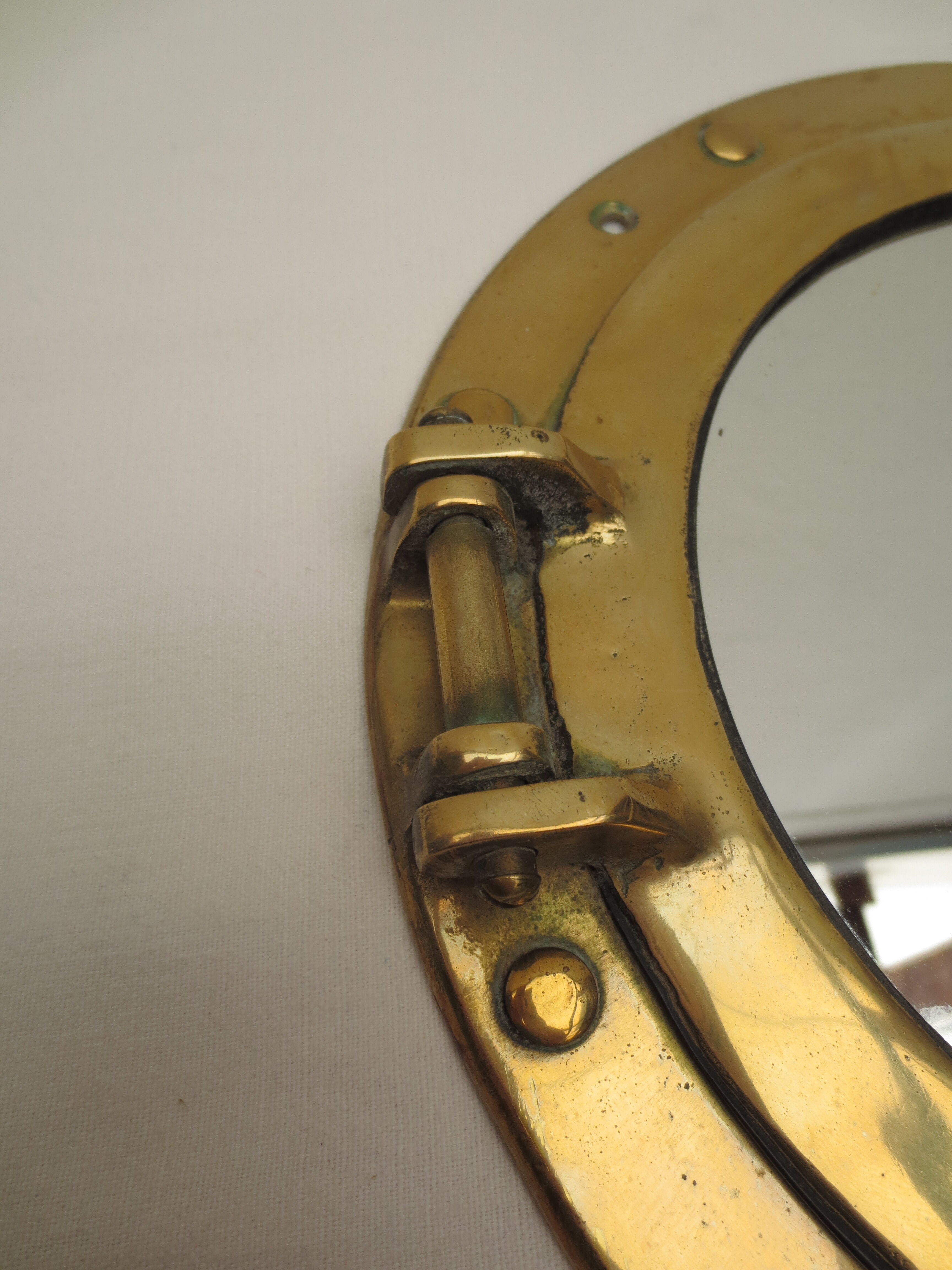 Mirror integrated into a brass navy porthole