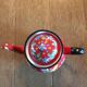 Red enamel teapot with hand-painted floral decoration