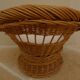 Wicker armchair with a high back and its boucle fabric cushion.