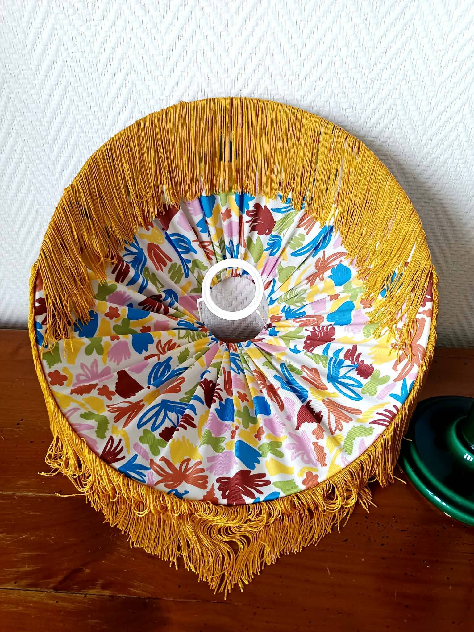 Green ceramic lamp with a vintage pleated fringe shade.