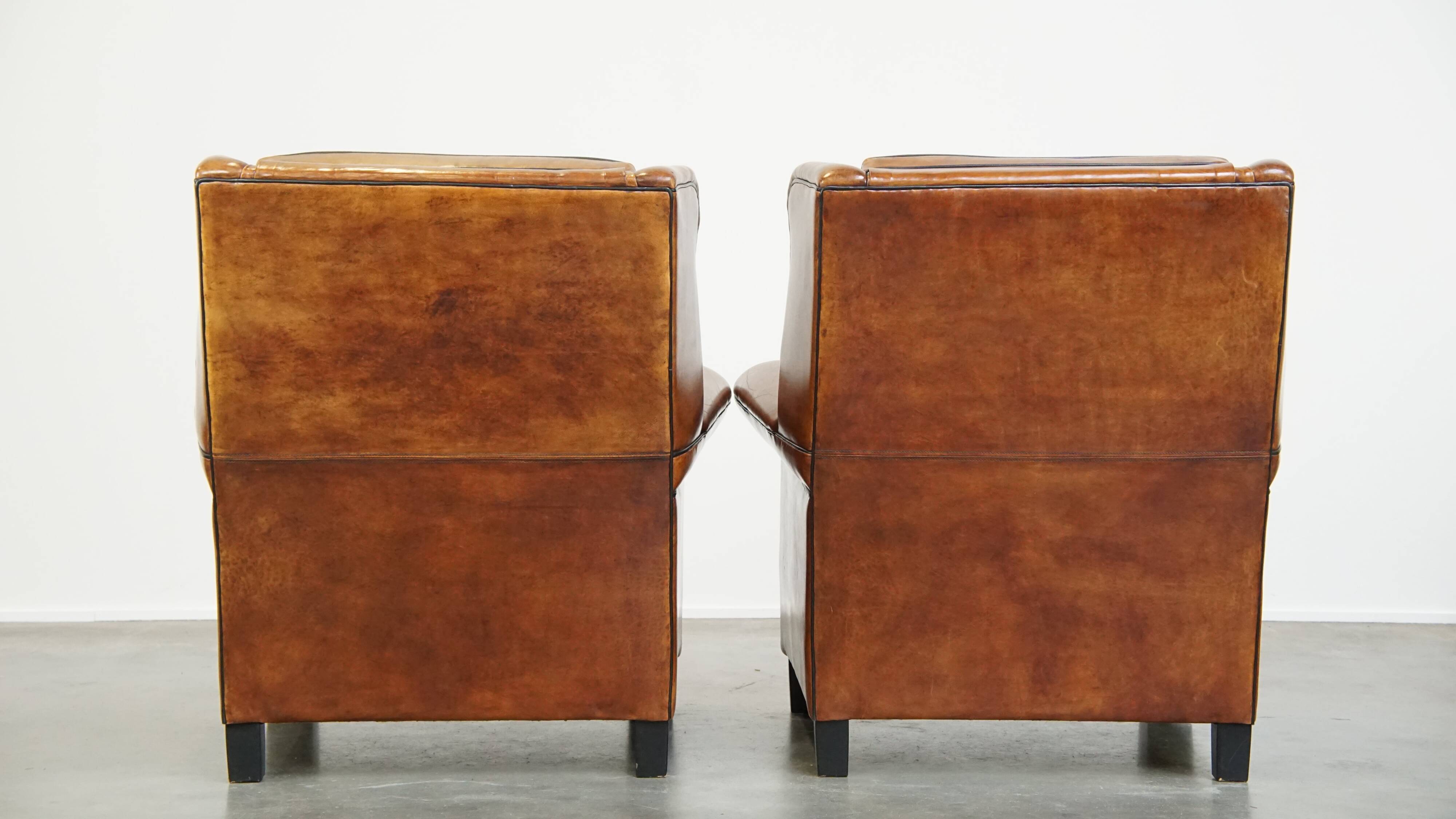 Set of 2 very comfortable large sheepskin armchairs elegantly finished with black piping