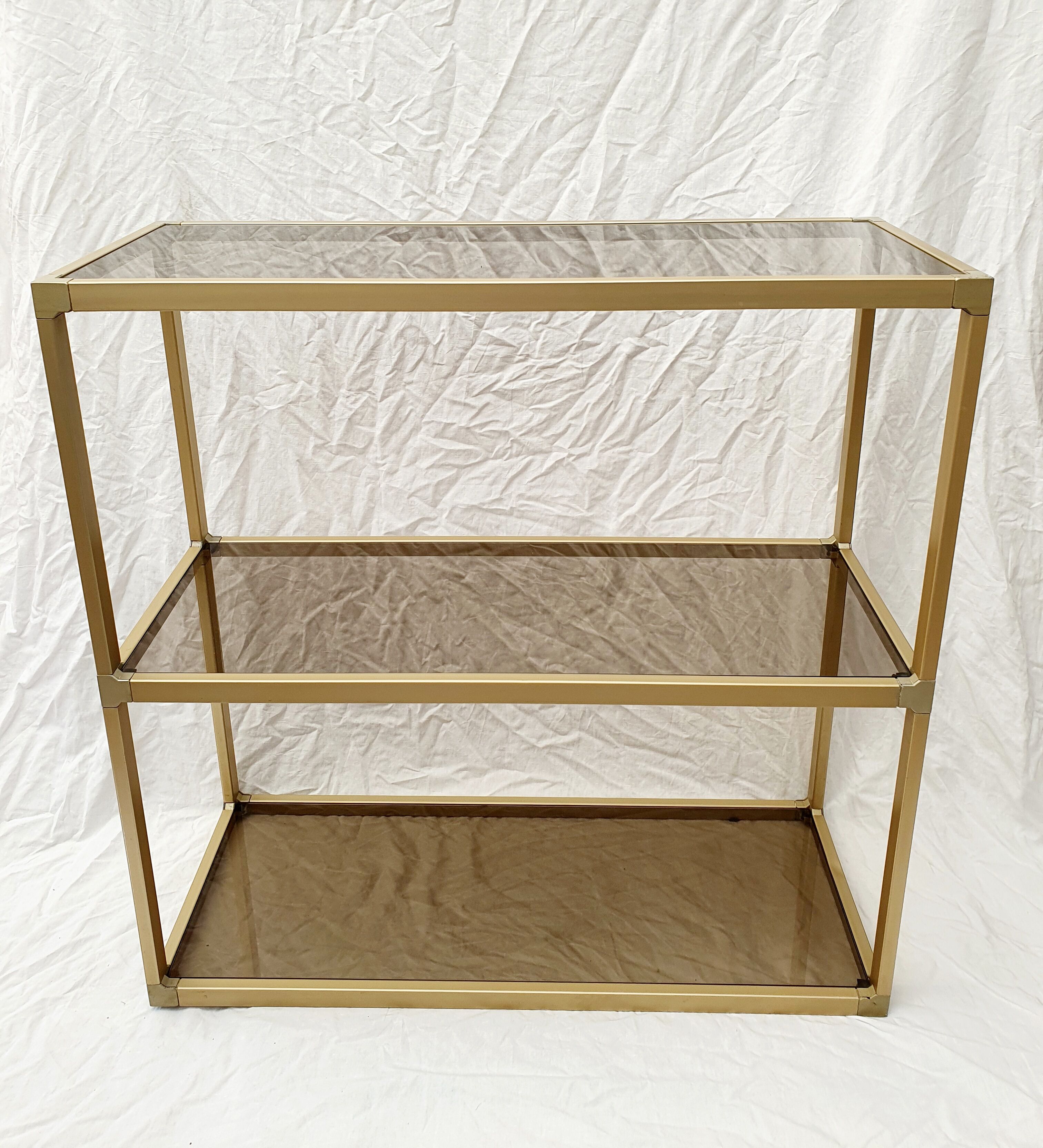 Golden metal shelf and smoked glass