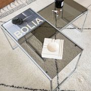 Set of 2 vintage nesting coffee tables in chrome metal and smoked glass.