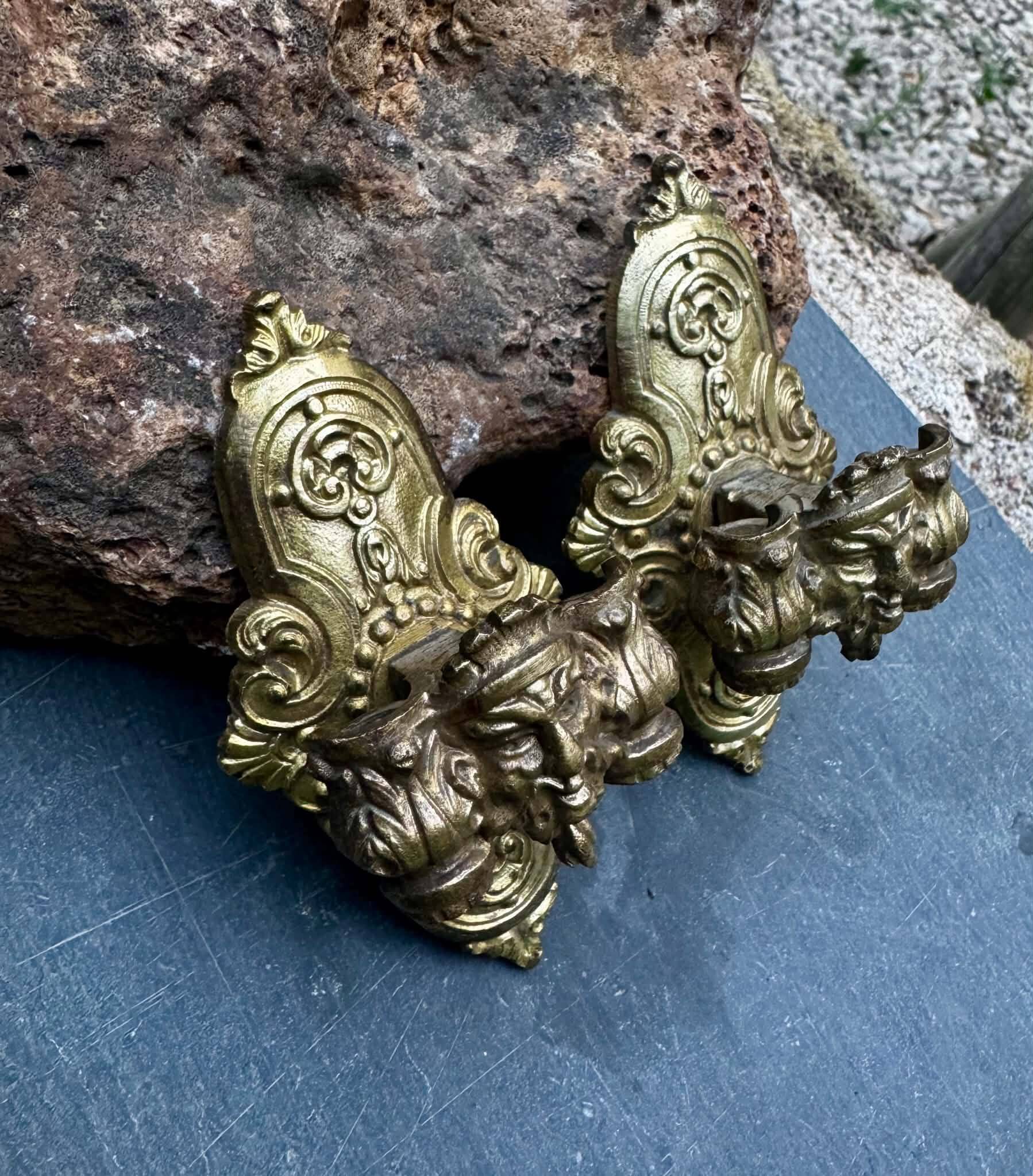 Pair of bronze wall sconces with mask, signed L. Pinet, Art Nouveau period.