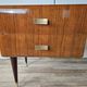 Mid-century drawer chest in mahogany, brass and glass.
