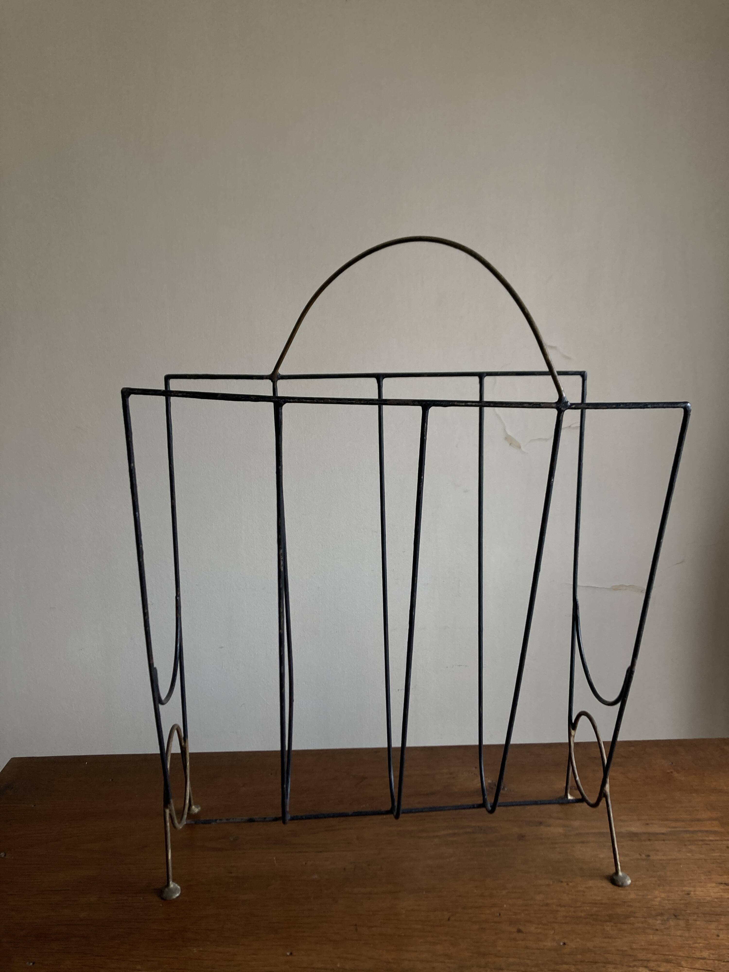 Mid-century poetic magazine rack in black metal