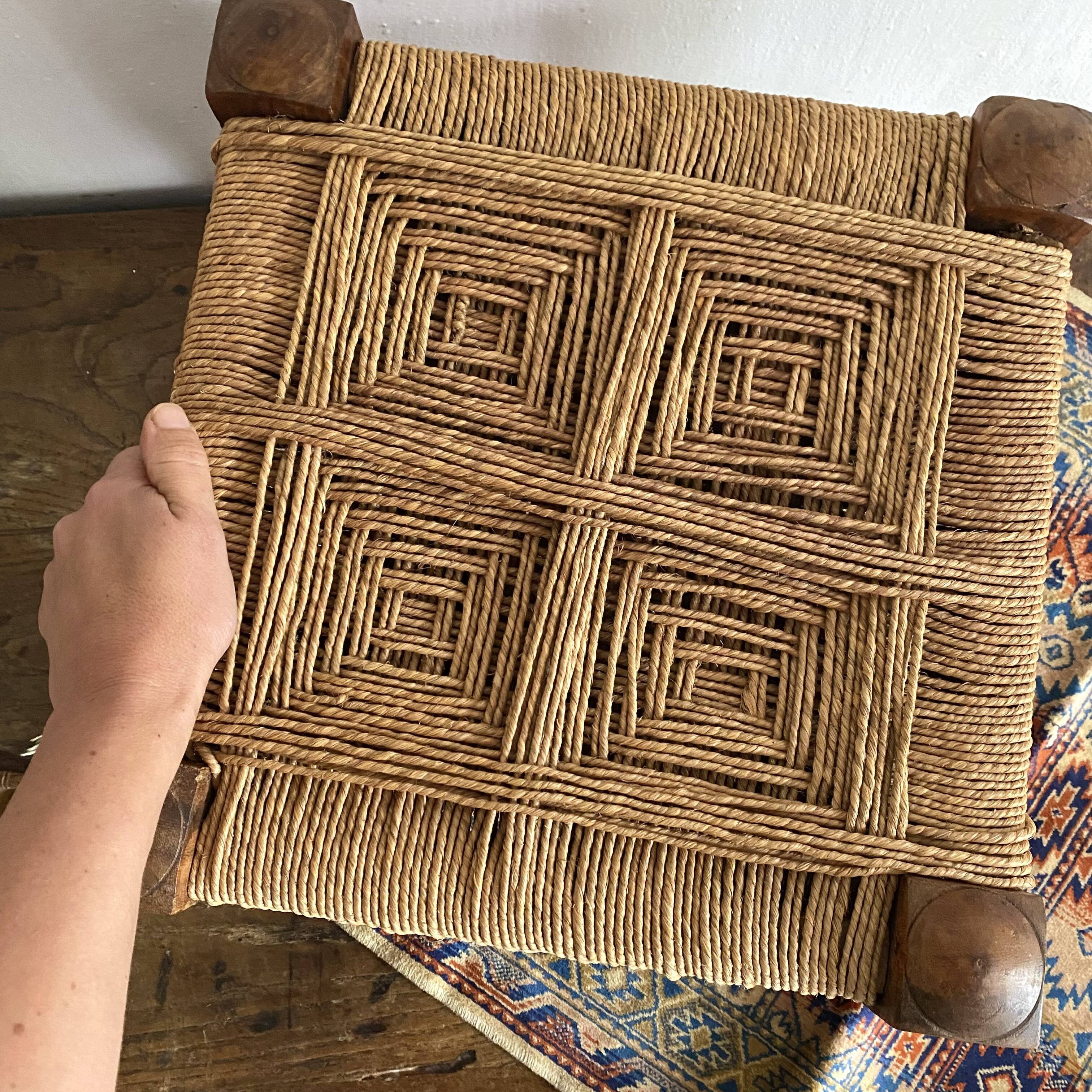 Low stool with carved wood and braided cord.