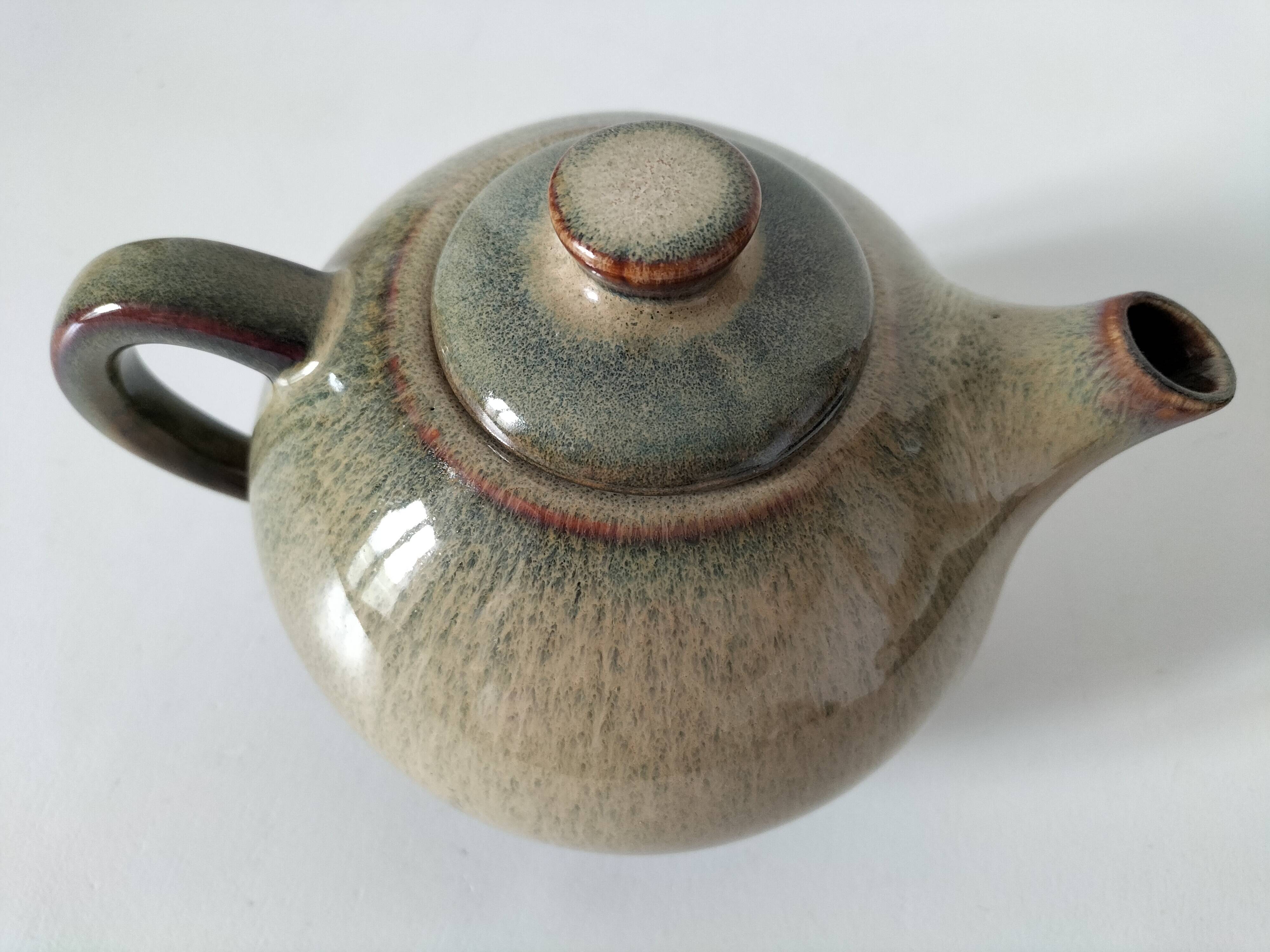 Vintage ceramic teapot with a flame design.
