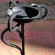Old ashtray on twisted hammered wrought iron legs, vintage decor.