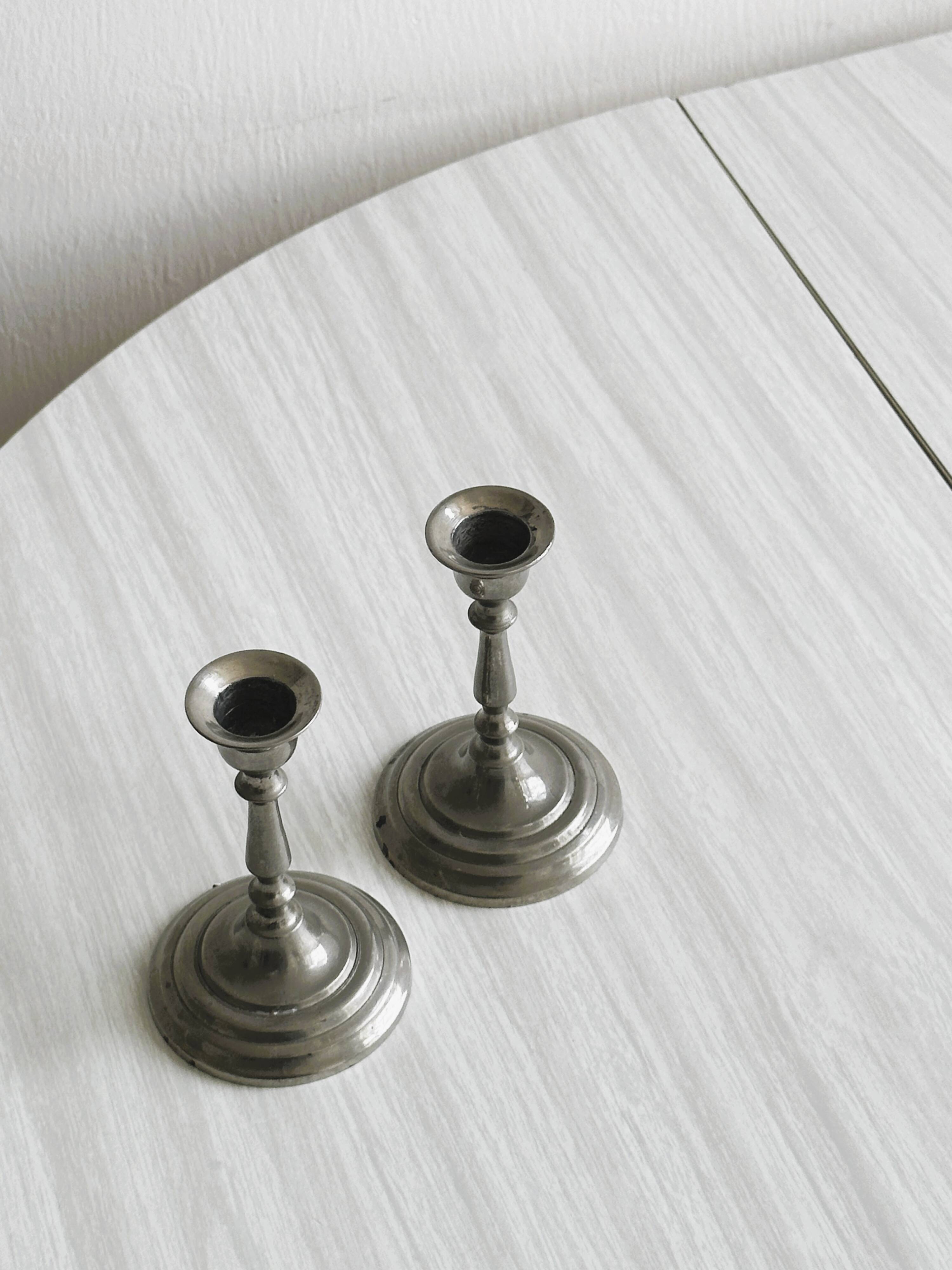 Pair of small metal candle holders, classic design.
