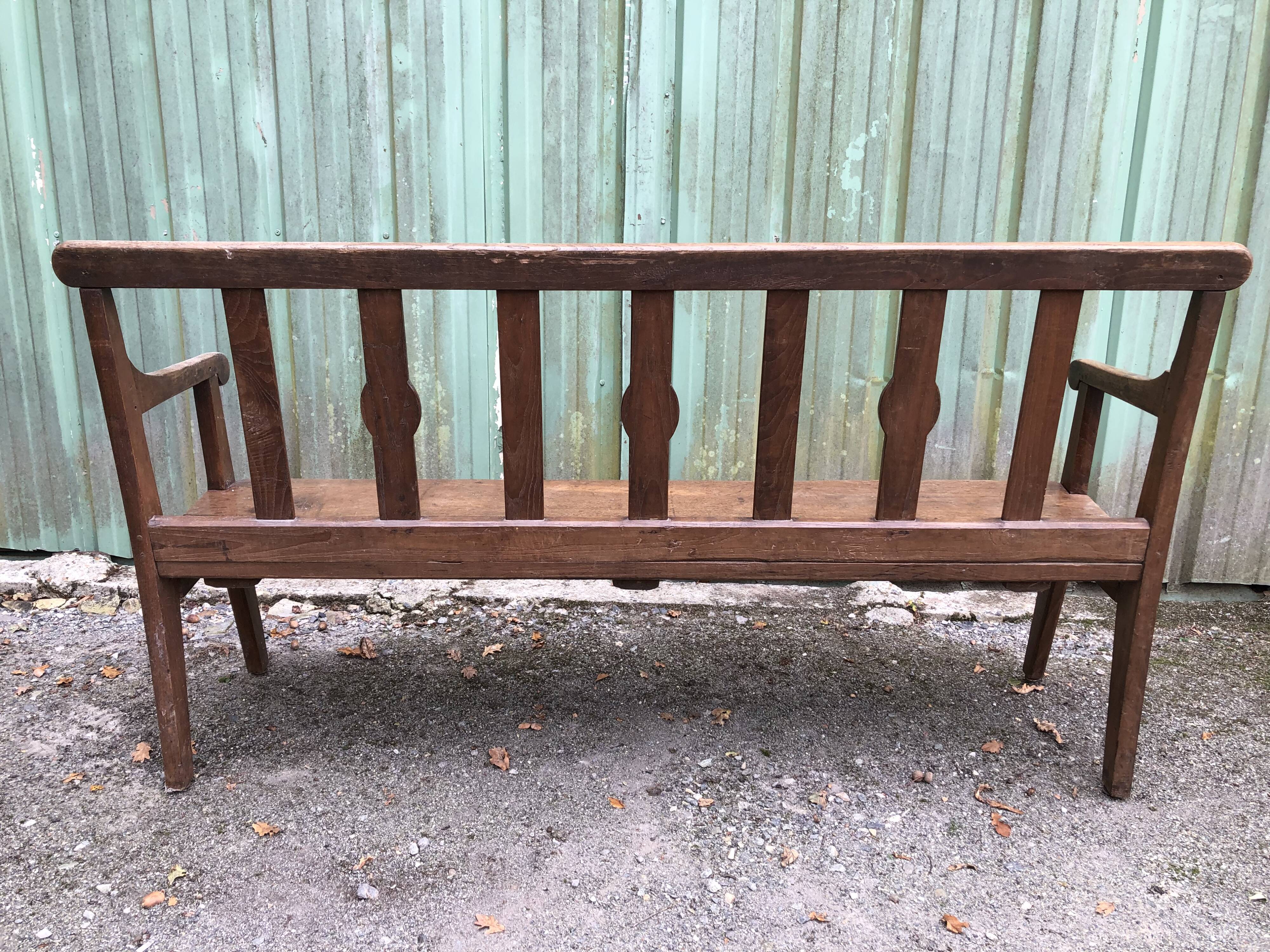 Duo of old solid oak benches with backs and armrests.