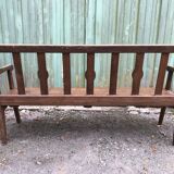 Duo of old solid oak benches with backs and armrests.