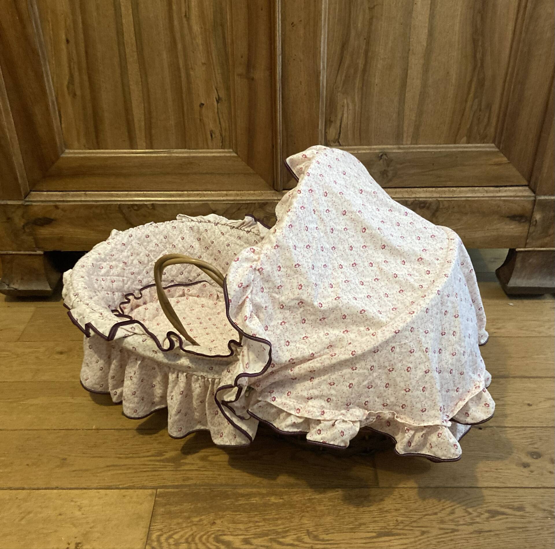 1960s wicker cradle with mattress and drapes.