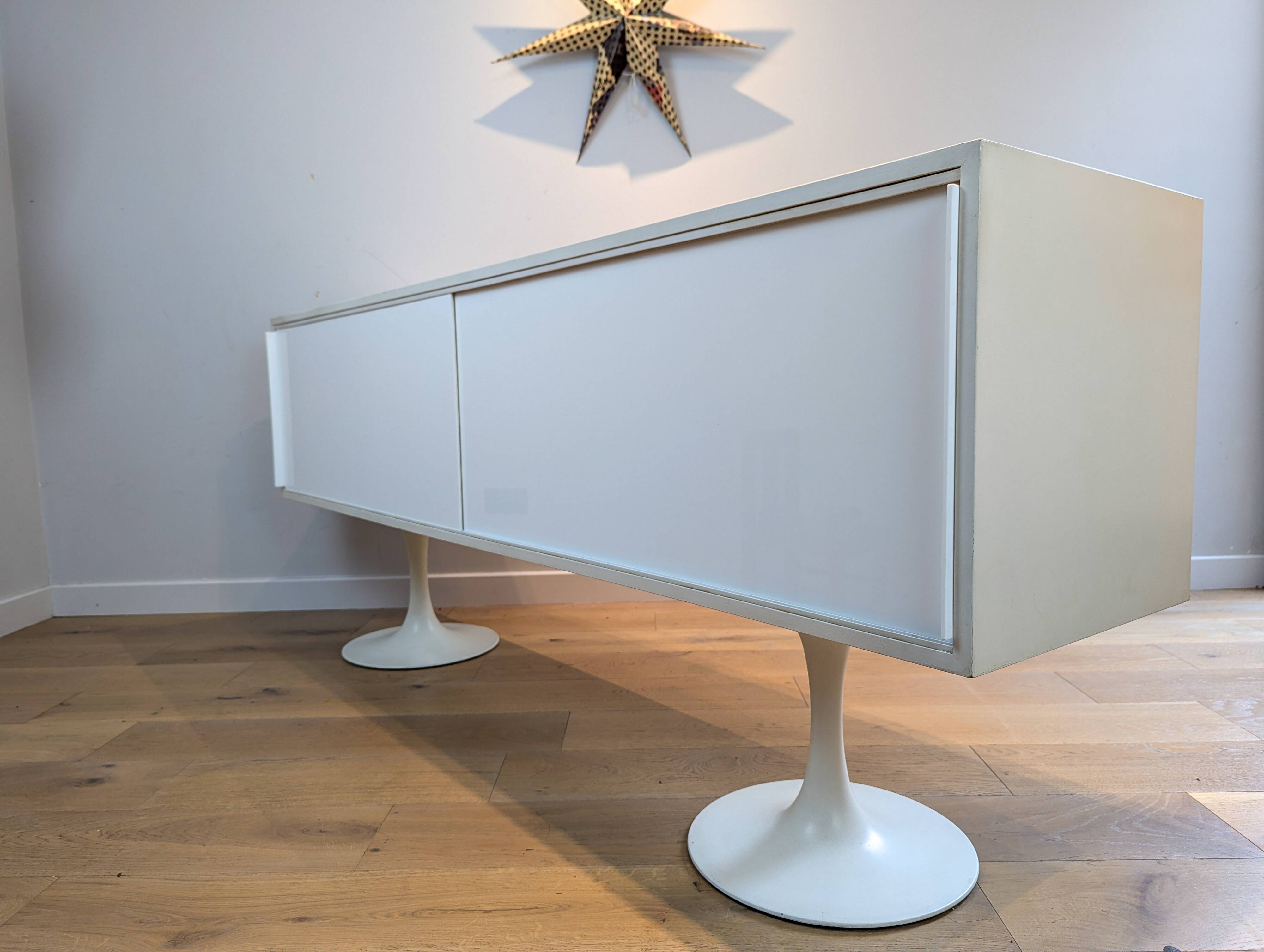 A vintage mid century space age sideboard with white sliding doors