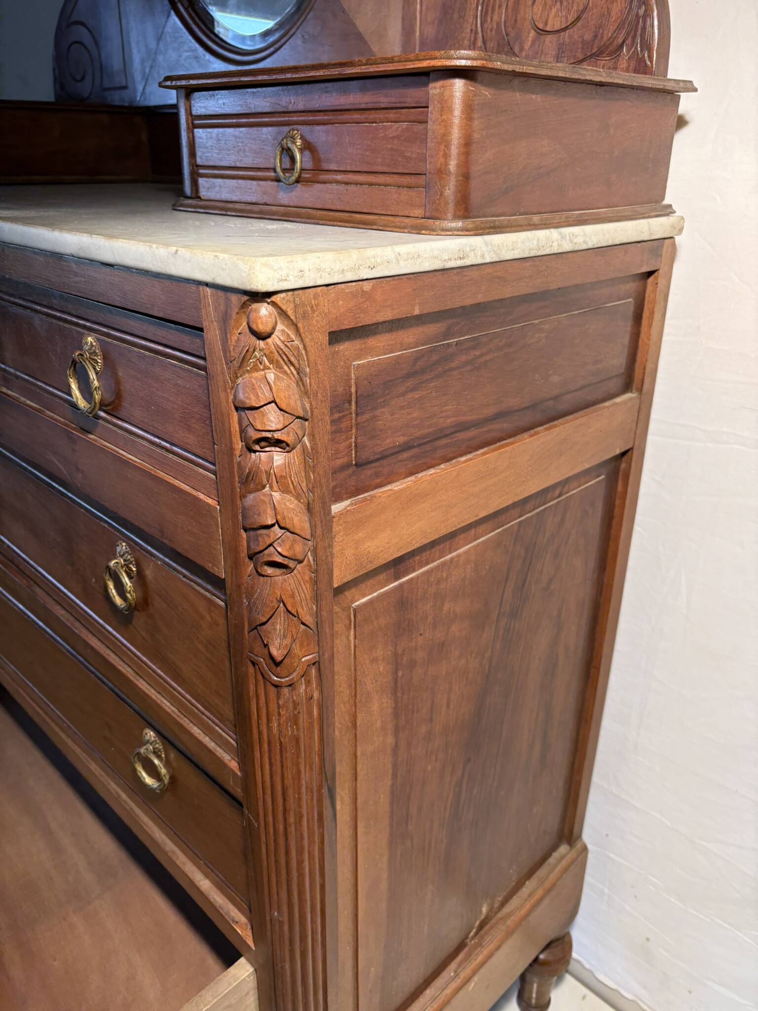 Antique carved wooden dressing table with marble and tilting oval mirror.
