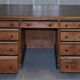 Antique Victorian oak kneehole desk with 18 double-sided drawers.