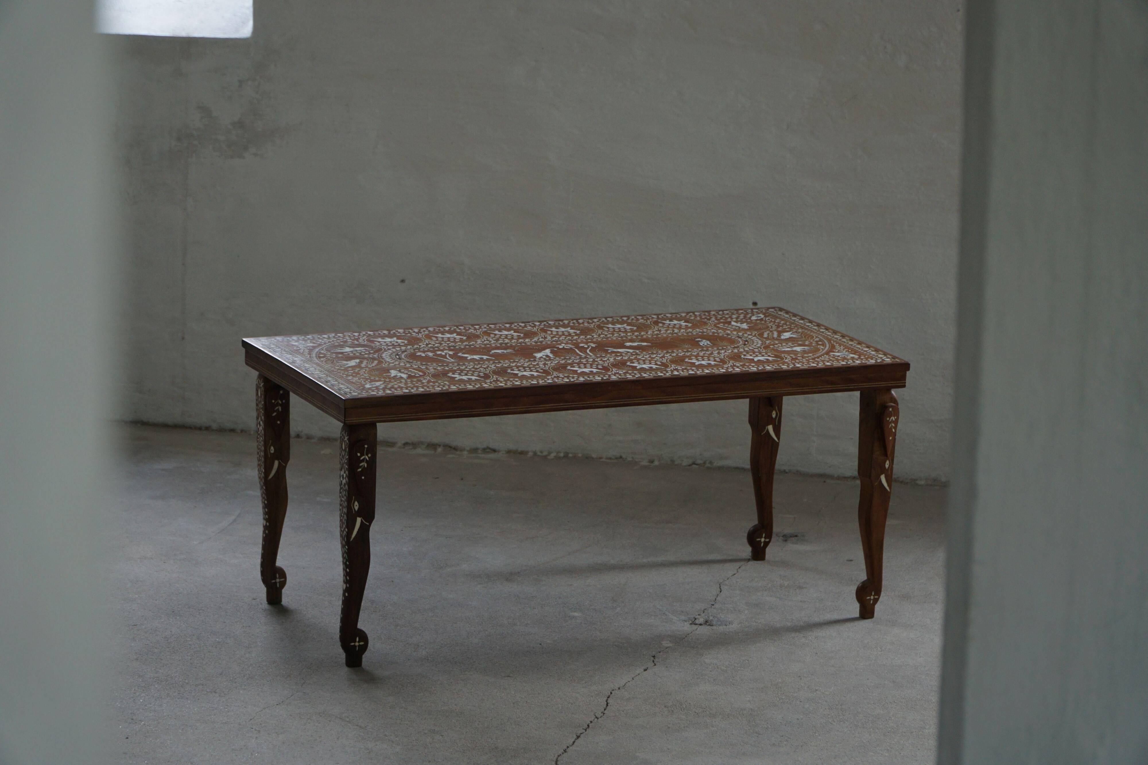 Vintage Indian teak coffee table inlaid with elephant motifs, mid-20th century.
