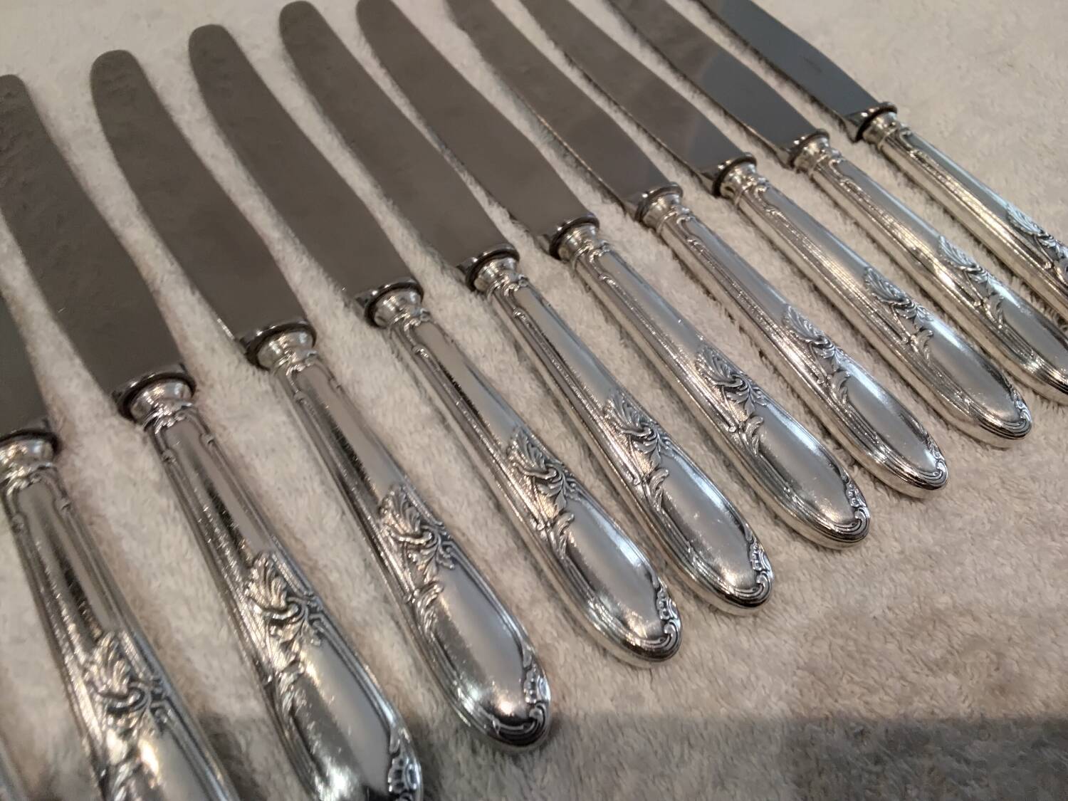 12 silver-plated metal dessert knives with rocaille ribbon decoration, 21.4 cm