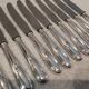 12 silver-plated metal dessert knives with rocaille ribbon decoration, 21.4 cm