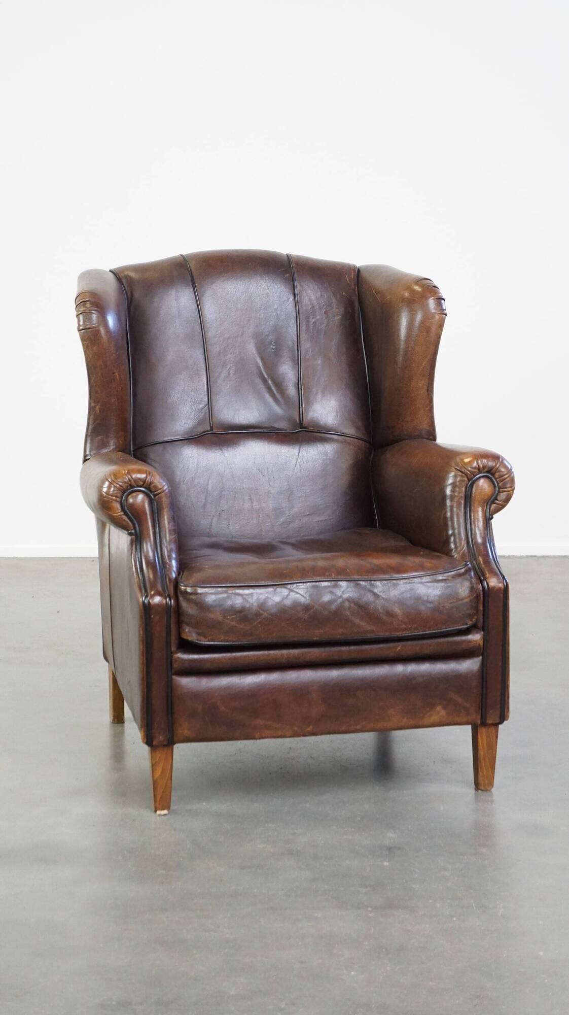 Wing chair made of sheepskin and neatly finished with black piping