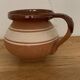 Hungarian folk ceramic pitcher in glossy brown and beige, traditional rounded pot.