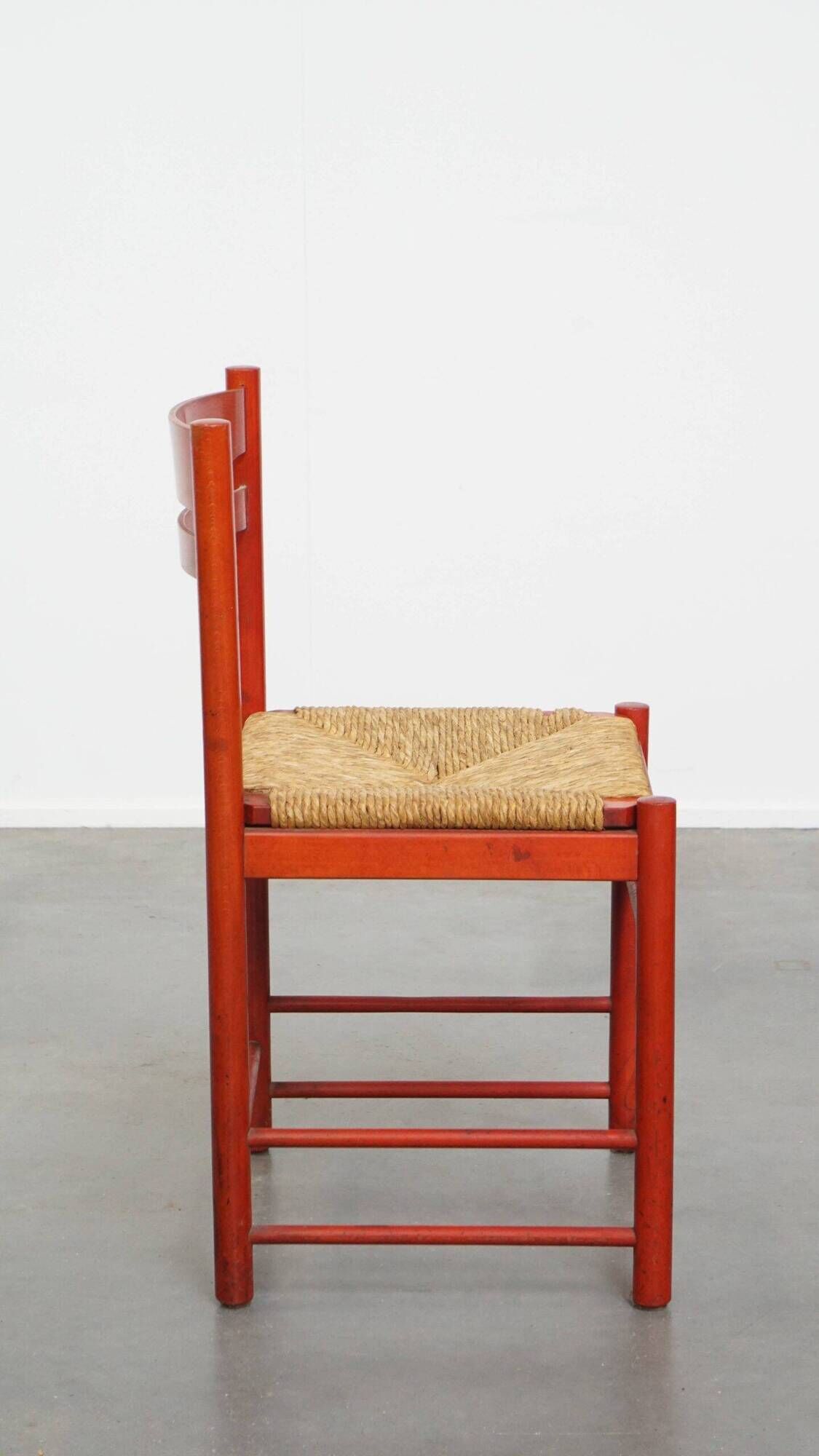Vintage 1970s red wooden chair with a woven wicker seat