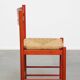 Vintage 1970s red wooden chair with a woven wicker seat