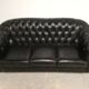 Three-seater black leather chesterfield sofa