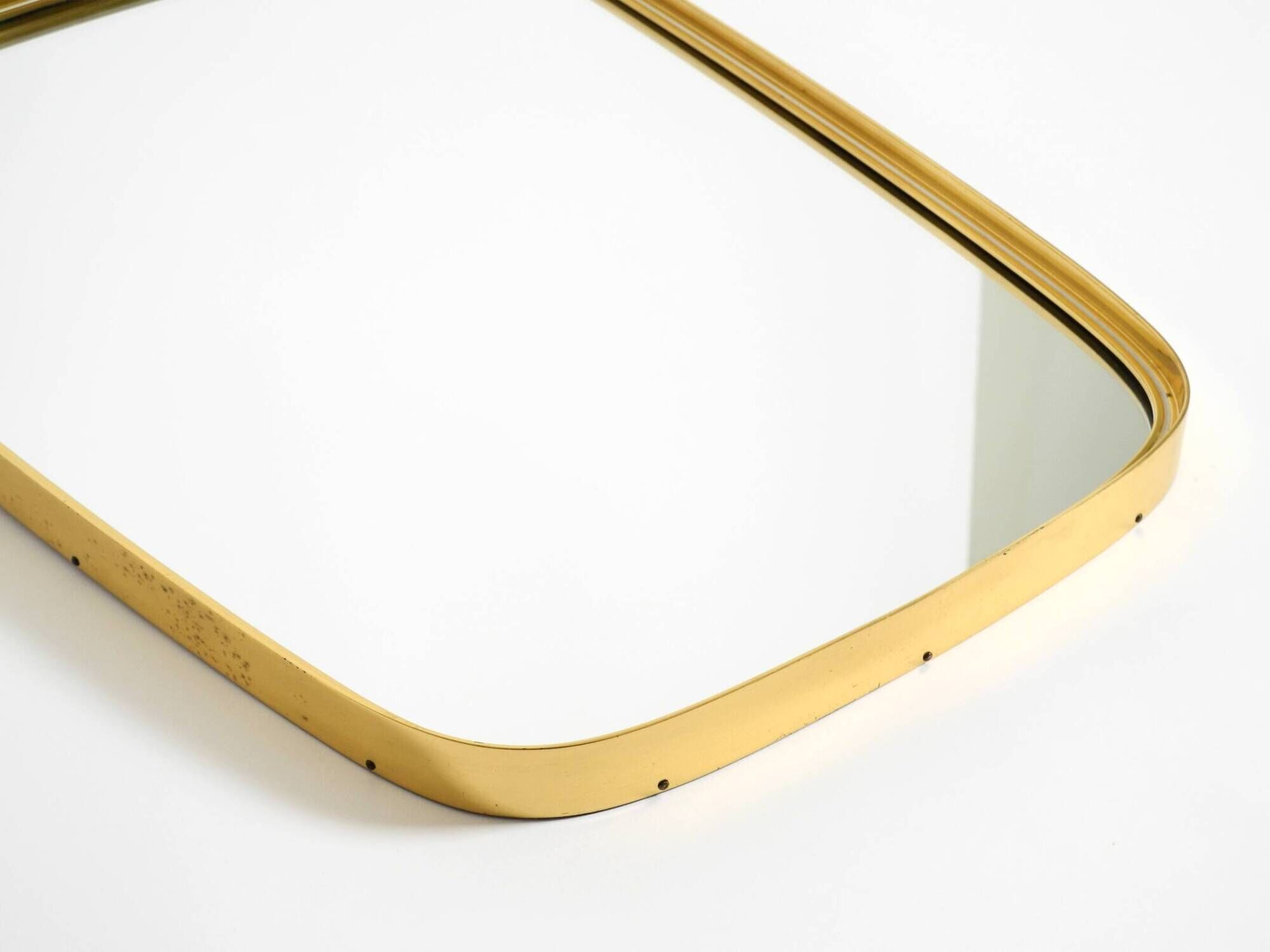 A pair of rare Mid Century "Münchener Zierspiegel" brass wall mirrors