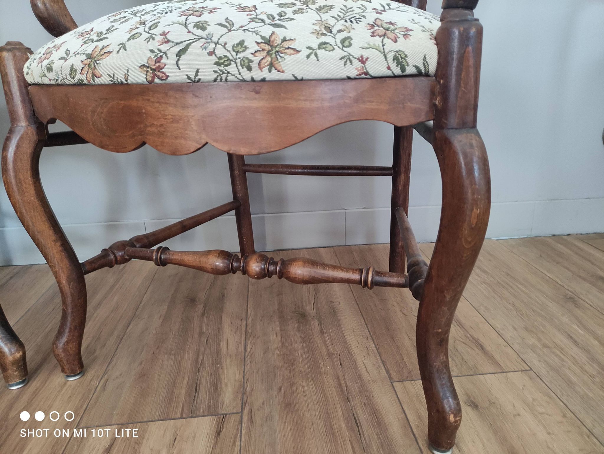 Pair of Provençal armchairs in brown wood and floral fabric.
