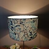 Table lamp with chrome stem, tropical plant shade.