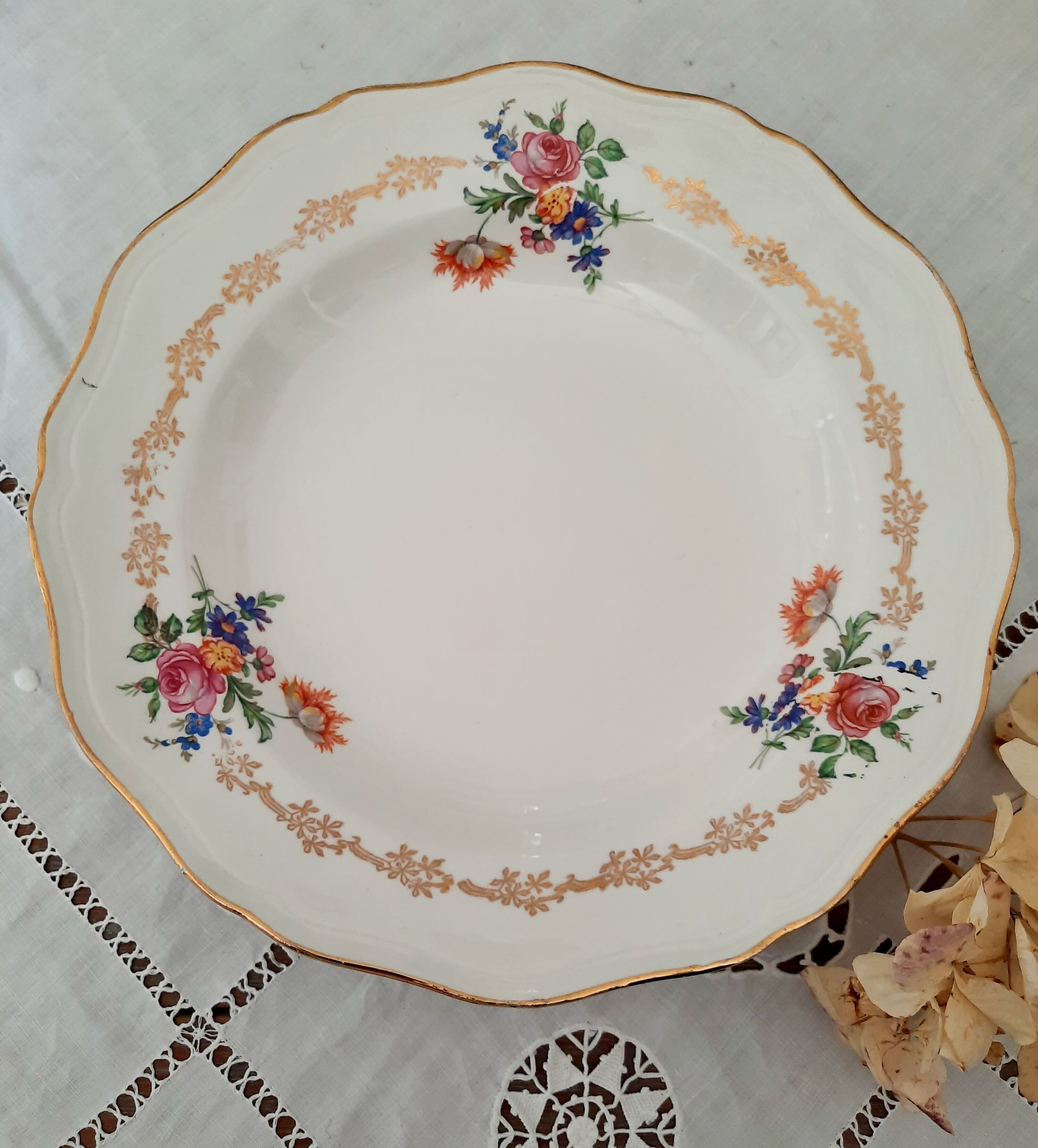 Old hollow plates mismatched in earthenware with gilded edges