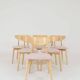 Set of 6 pale pink dining chairs in natural wood.