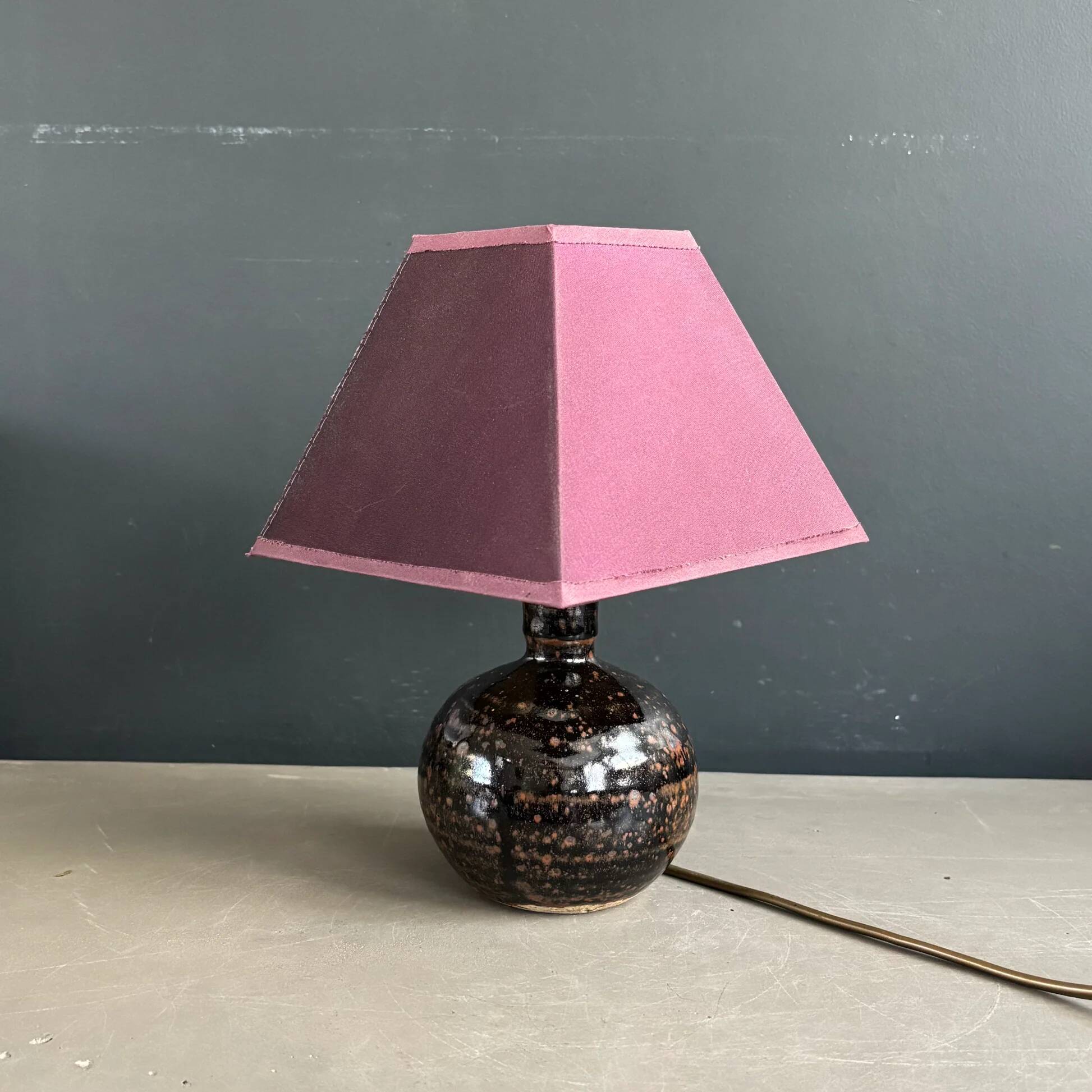 Ceramic floor lamp with a pyramidal shade and square base.