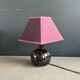 Ceramic floor lamp with a pyramidal shade and square base.