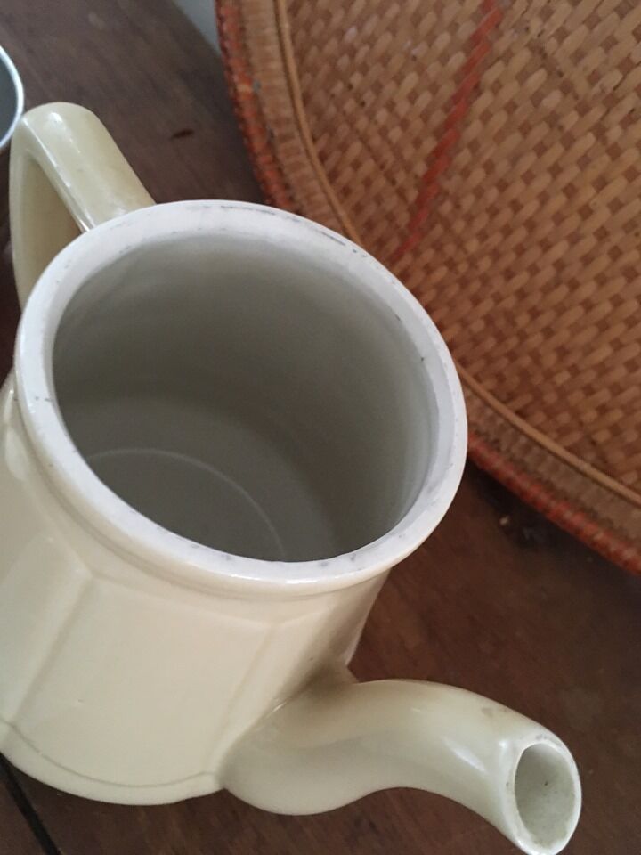 Old tea pot or coffee maker in faience cream with filter.